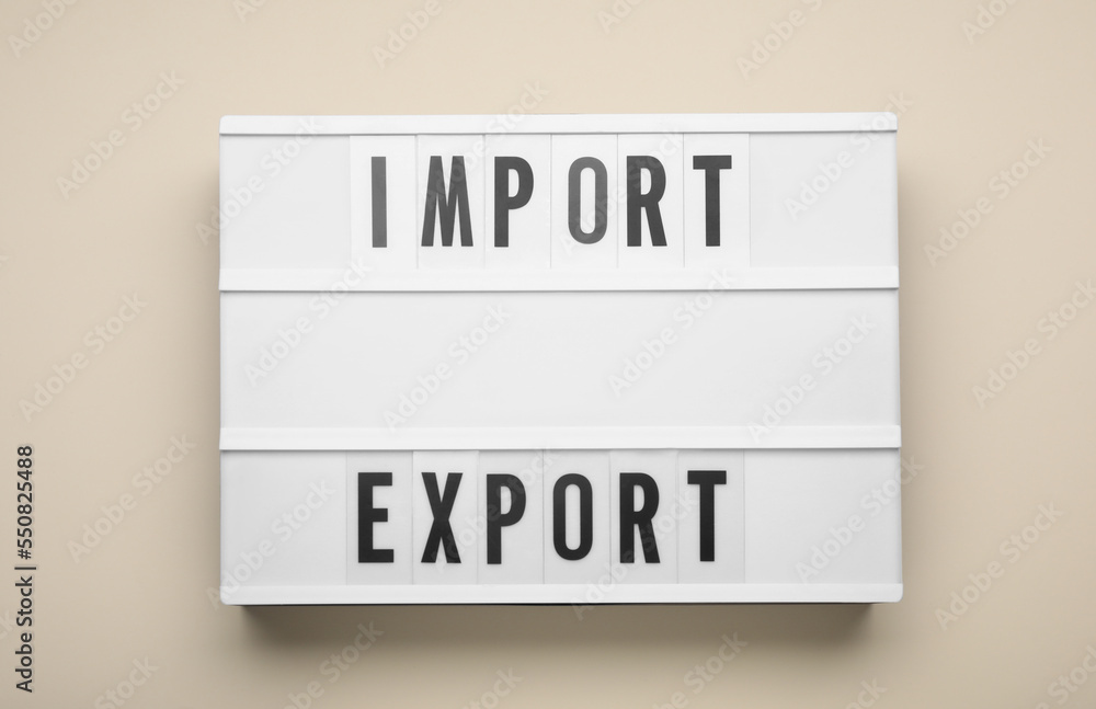 Lightbox with words Import and Export on beige background, top view Lightbox with words Import and Export on beige background, top view