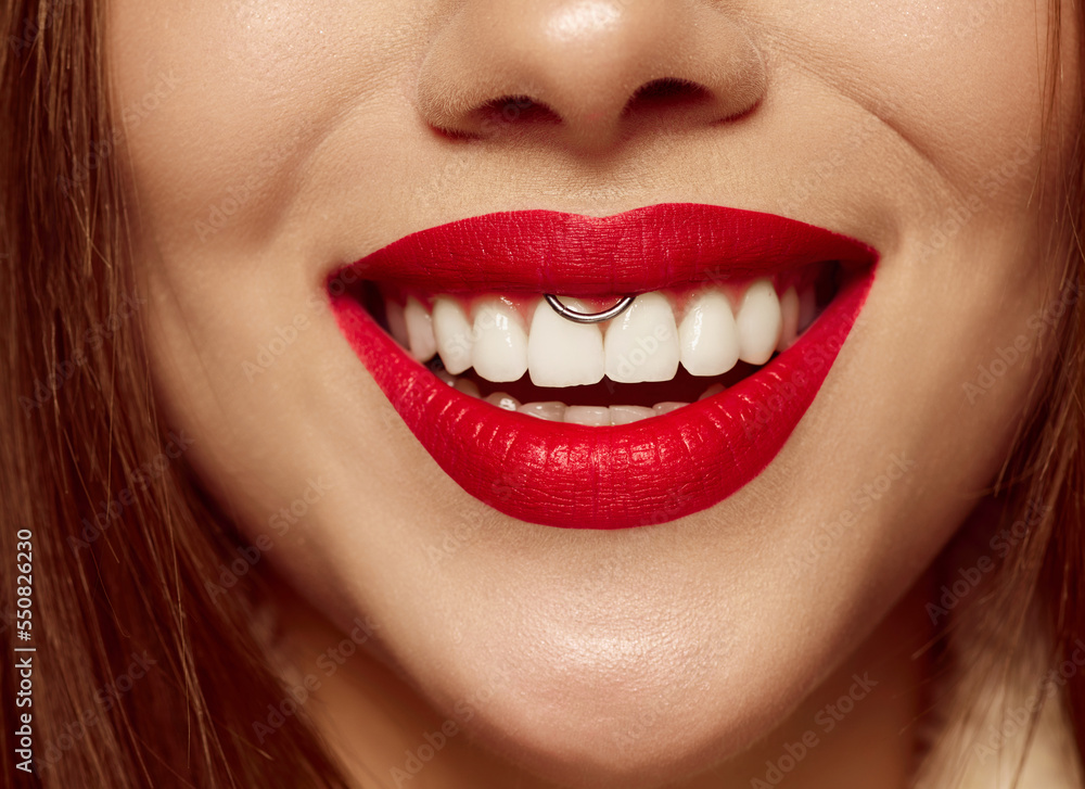 Fototapeta premium Closeup view of female mouth with bright red lipstick. Beautiful wide smile of young woman with great healthy white teeth