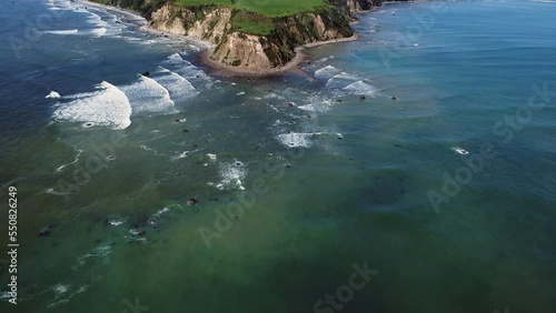 Foamy Waves Splashing On Stony Shore Of Maketu Beach In North Island, New Zealand - aerial drone shot photo