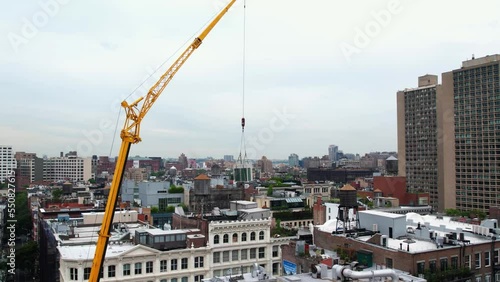 Aerial view following a crane lifting a ventilation system on a roof in New York photo