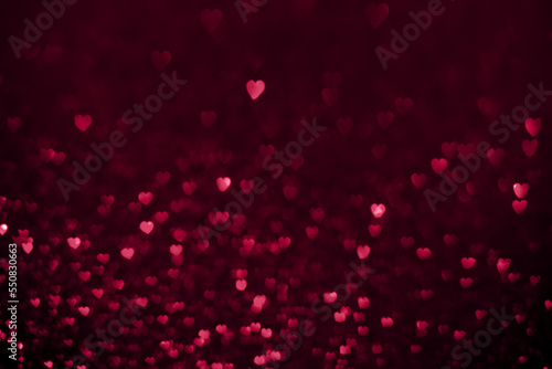 Trendy viva magenta color of the year 2023, pink red hearts, sparkling glitter bokeh background, valentines day abstract defocused texture