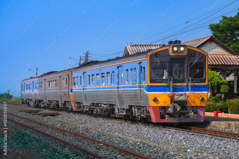 Diesel railcar on the railway at the railway station. (Building is public)