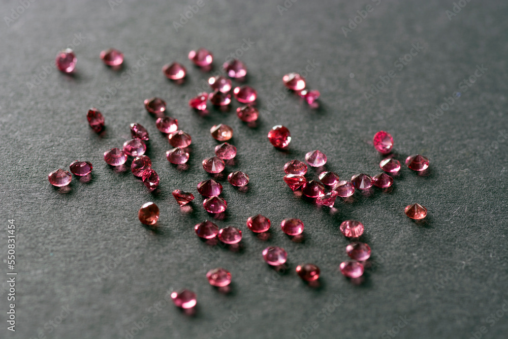 Scattering of natural rich cherry, raspberry rich red round genuine spinel gemstones. Colorful matched small natural unheated spinel gemstone faceted settings. Black paper background. Craft supplies. Scattering of natural rich cherry, raspberry rich red round genuine spinel gemstones. Colorful matched small natural unheated spinel gemstone faceted settings. Black paper background. Craft supplies.