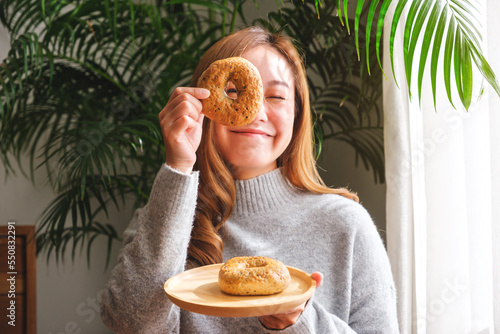 Принти на полотні Portrait image of a young woman in sweater holding and playing with a piece of b