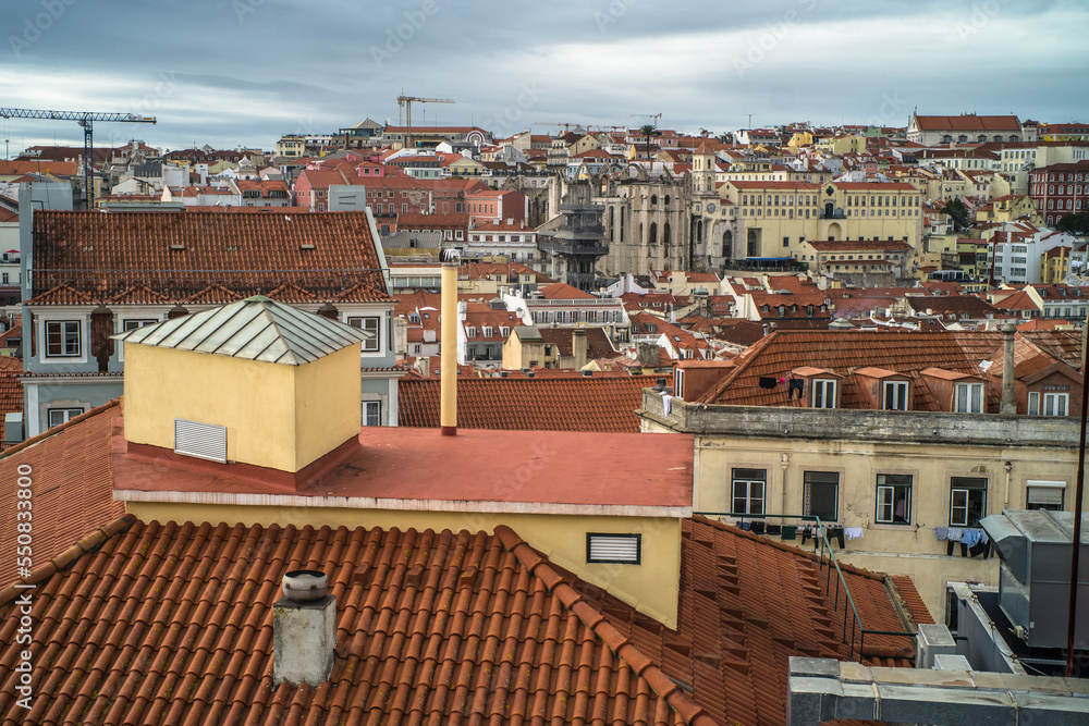 historic buildings of the old town of lisbon. Old colorful buildings, narrow streets, historic churches. Tiled roofs. View from the top of the viewpoint on the tenement houses and monuments. Clouds