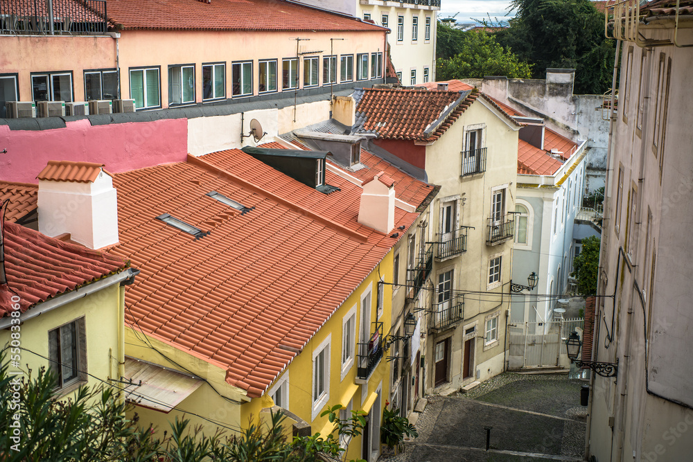 historic buildings of the old town of lisbon. Old colorful buildings, narrow streets, historic churches. Tiled roofs. View from the top of the viewpoint on the tenement houses and monuments. Clouds historic buildings of the old town of lisbon. Old colorful buildings, narrow streets, historic churches. Tiled roofs. View from the top of the viewpoint on the tenement houses and monuments. Clouds
