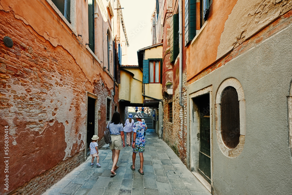 Family walk on the streets of Venice, Italy.