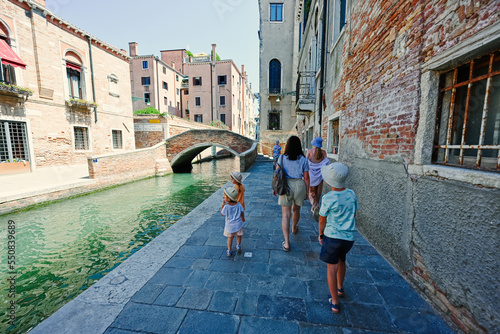 Mother with kids walking near canal in Venice, Italy. © AS Photo Family