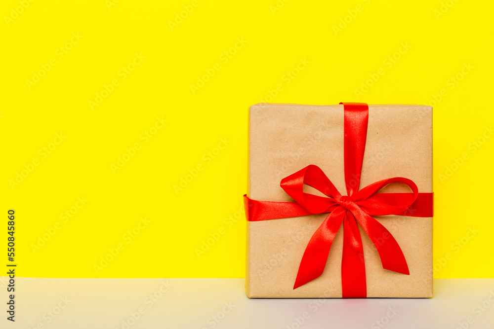 holiday brown paper present tied red ribbon bow top view with copy space. Flat lay holiday background. Birthday or christmas present. Christmas gift box concept with copy space holiday brown paper present tied red ribbon bow top view with copy space. Flat lay holiday background. Birthday or christmas present. Christmas gift box concept with copy space