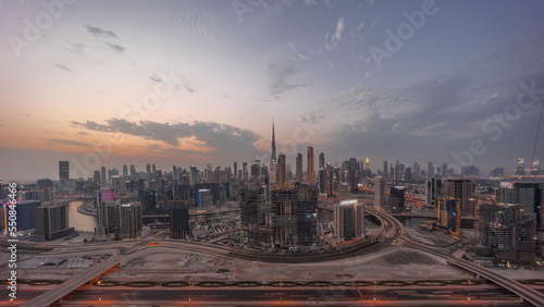 Panoramic skyline of Dubai with business bay and downtown district day to night timelapse.