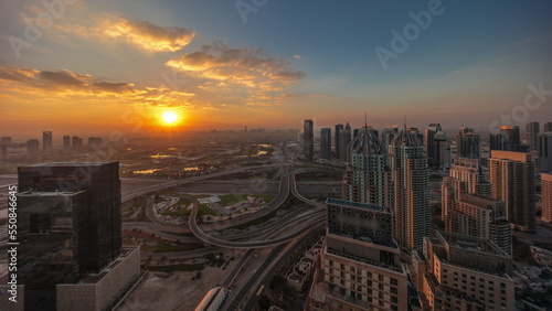 Sunrise over Dubai marina and JLT skyscrapers along Sheikh Zayed Road aerial timelapse.