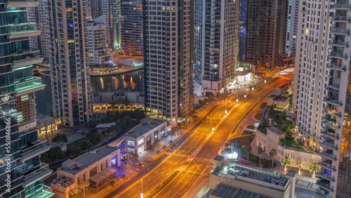 Aerial view on Dubai Marina skyscrapers and the most luxury yacht in harbor night to day timelapse, Dubai, United Arab Emirates