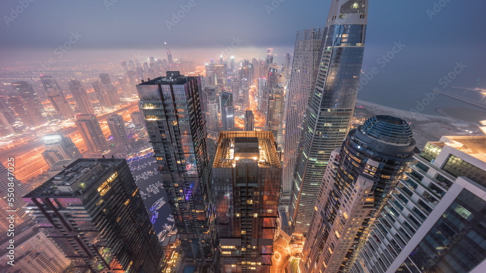Skyline panoramic view of Dubai Marina showing canal surrounded by skyscrapers along shoreline night to day timelapse. DUBAI, UAE Skyline panoramic view of Dubai Marina showing canal surrounded by skyscrapers along shoreline night to day timelapse. DUBAI, UAE