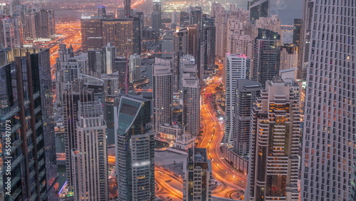 Skyline view of Dubai Marina showing canal surrounded by skyscrapers along shoreline night to day timelapse. DUBAI, UAE