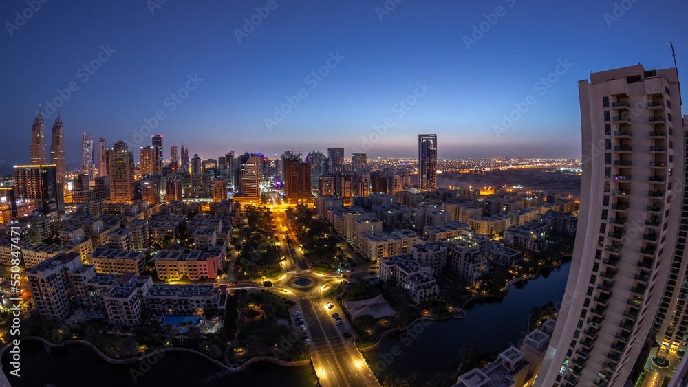 Obraz premium Skyscrapers in Barsha Heights district and low rise buildings in Greens district aerial night to day timelapse.