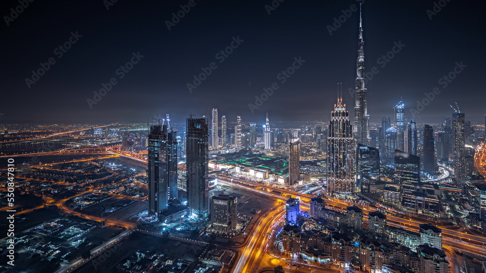 Obraz premium Panorama showing aerial view of tallest towers in Dubai Downtown skyline and highway night timelapse.
