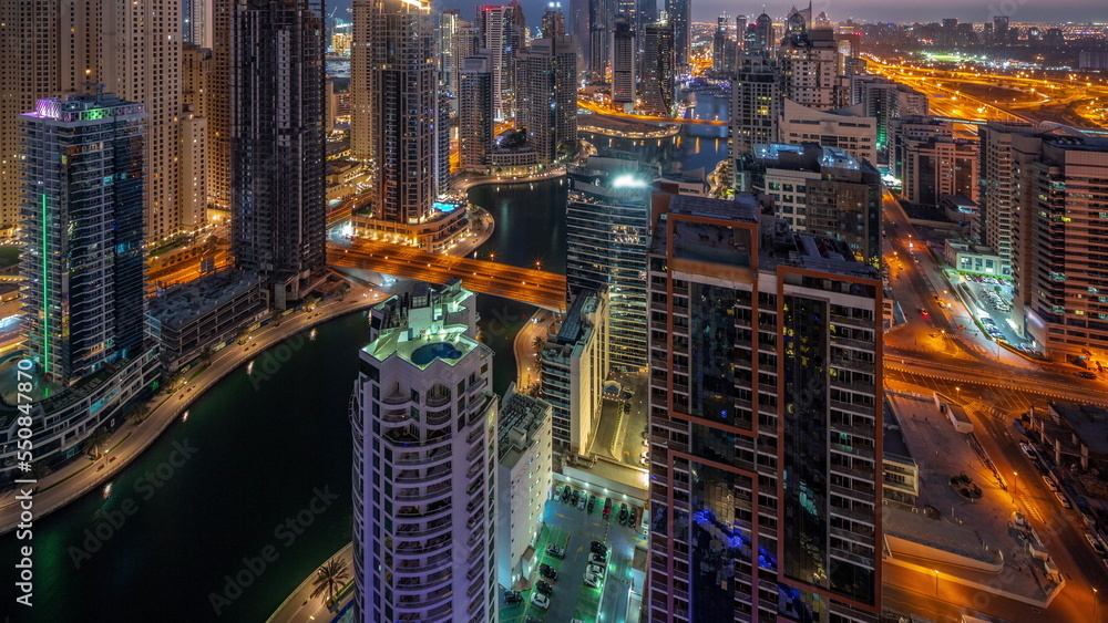 View of various skyscrapers in tallest recidential block in Dubai Marina aerial night to day timelapse