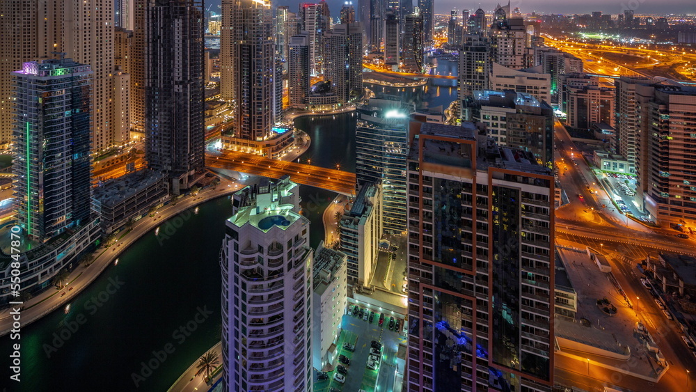 Naklejka premium View of various skyscrapers in tallest recidential block in Dubai Marina aerial night to day timelapse
