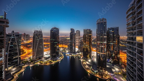 Tall residential buildings at JLT aerial night to day timelapse, part of the Dubai multi commodities centre mixed-use district. photo