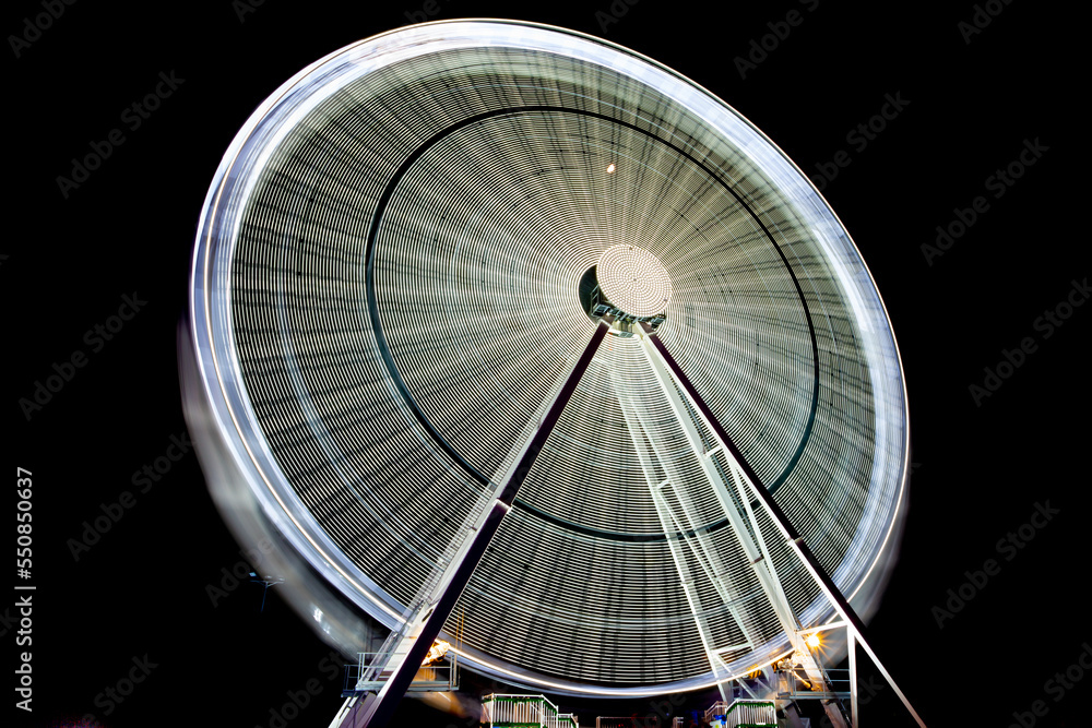 Giant white Ferris wheel in motion. Outdoor attractions. Christmas holidays.
