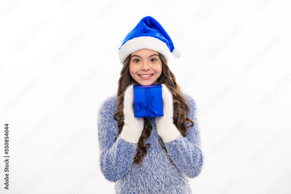 Christmas and New Year concept. Smiling teen kid girl holding a present gifts box. Teen girl in christmas winter sweater, copy space. Teen santa girl. Christmas and New Year concept. Smiling teen kid girl holding a present gifts box. Teen girl in christmas winter sweater, copy space. Teen santa girl.