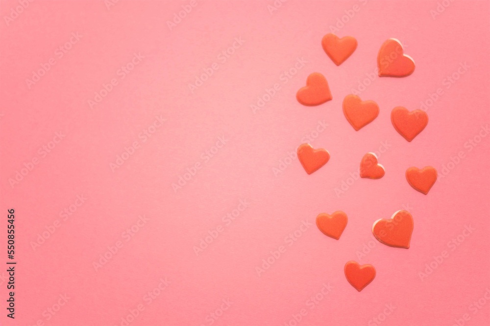 Red hearts on pink paper table. Copy space.