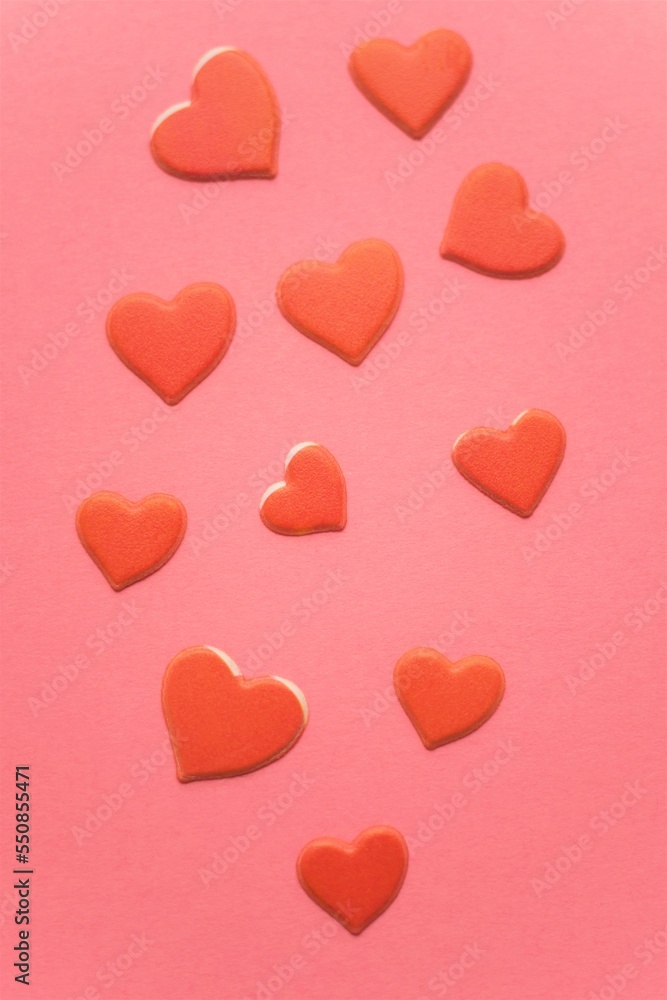 Red hearts on pink paper table.