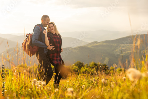 Happy traveler young couple resting in the mountains at sunset in spring or summer season. © Angelov