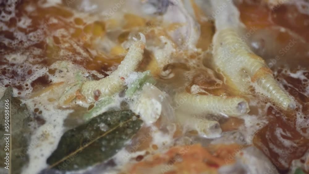 adding salt to cheap chicken feet soup, close-up, top view adding salt to cheap chicken feet soup, close-up, top view