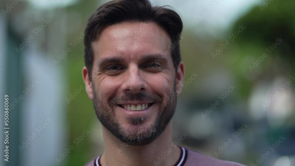 Portrait of a young man closeup face looking at camera walking toward camera smiling. 30s male handsome person Portrait of a young man closeup face looking at camera walking toward camera smiling. 30s male handsome person