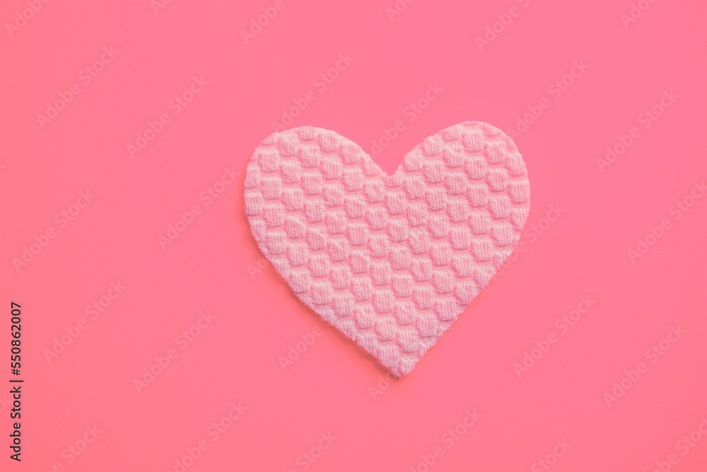 Fabric heart on vivid pink table. Art card