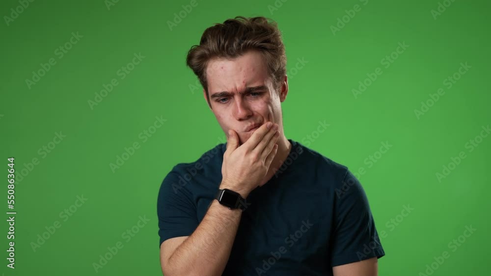 Slow motion portrait of young hipster man 20s with tooth dental ache pain problem in mouth isolated on green screen background in studio Slow motion portrait of young hipster man 20s with tooth dental ache pain problem in mouth isolated on green screen background in studio