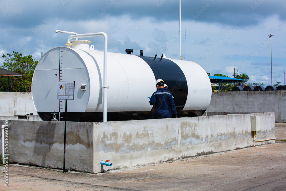 Male workers are for check record inspection of storage tank oil Male workers are for check record inspection of storage tank oil