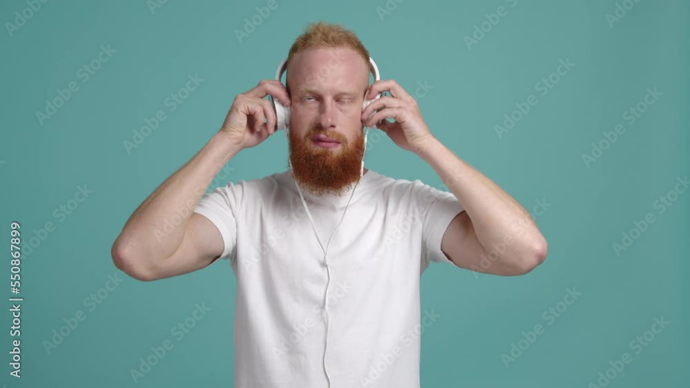 Portrait of a cheerful guy starting to dance while listening to the music. Young, caucasian man in his 30s looking joyful and happy. High quality 4k footage Portrait of a cheerful guy starting to dance while listening to the music. Young, caucasian man in his 30s looking joyful and happy. High quality 4k footage