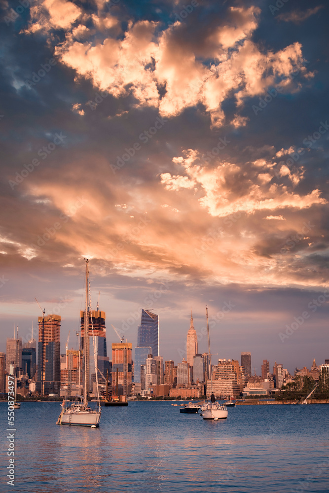 New York City skyline with skyscrapers, new construction, Hudson River  and sunset as seen from New Jersey