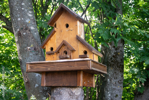 Hand made wooden shelter, bird house, placed on the tree in forest, birdwatchers stop place to enjoy ornithology  © Miros