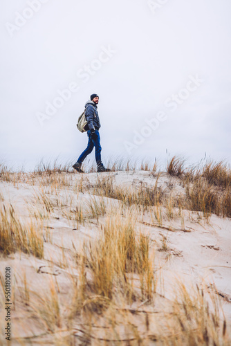Man trekking on dunes by the sea at autumn © Photocreo Bednarek
