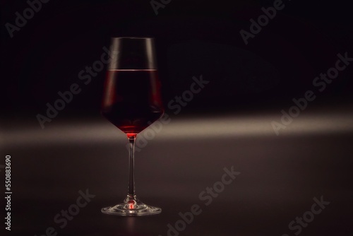 Glass of red wine. Grey and black stylish background.
