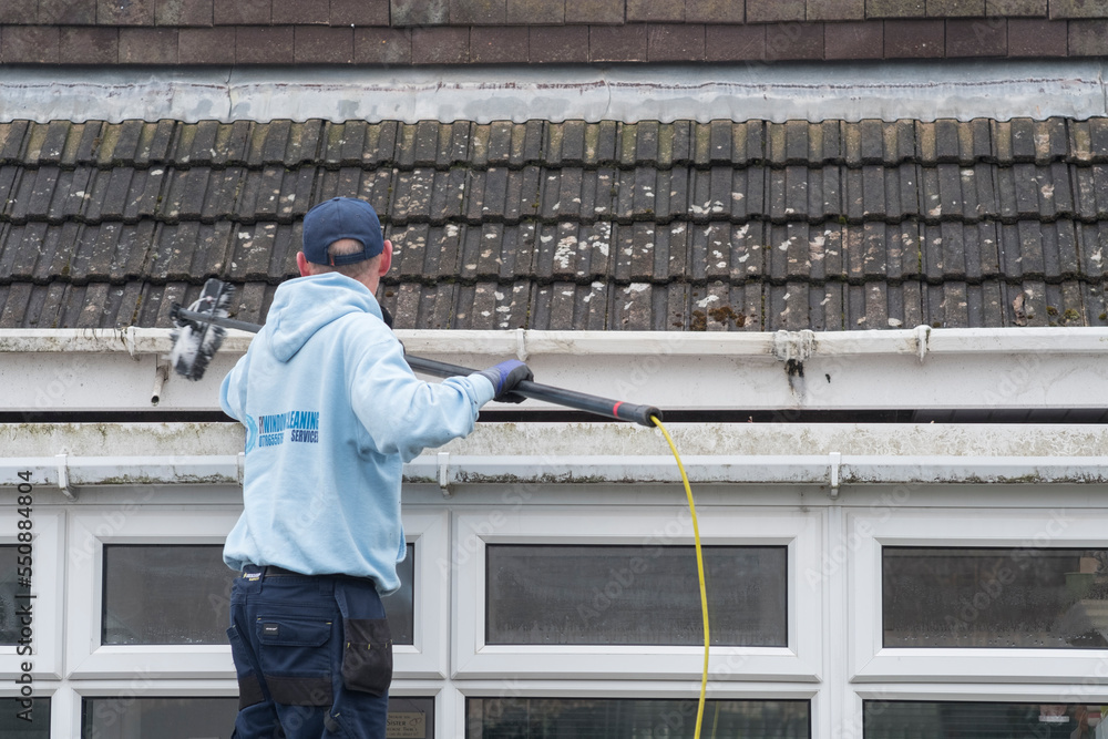 Foto de A window and gutter cleaner cleaning Dirty clogged white