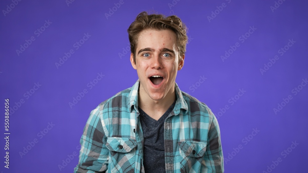 Portrait of amazed young man 20s shocked, saying WOW. Handsome guy surprised isolated on solid purple background. Portrait of amazed young man 20s shocked, saying WOW. Handsome guy surprised isolated on solid purple background.
