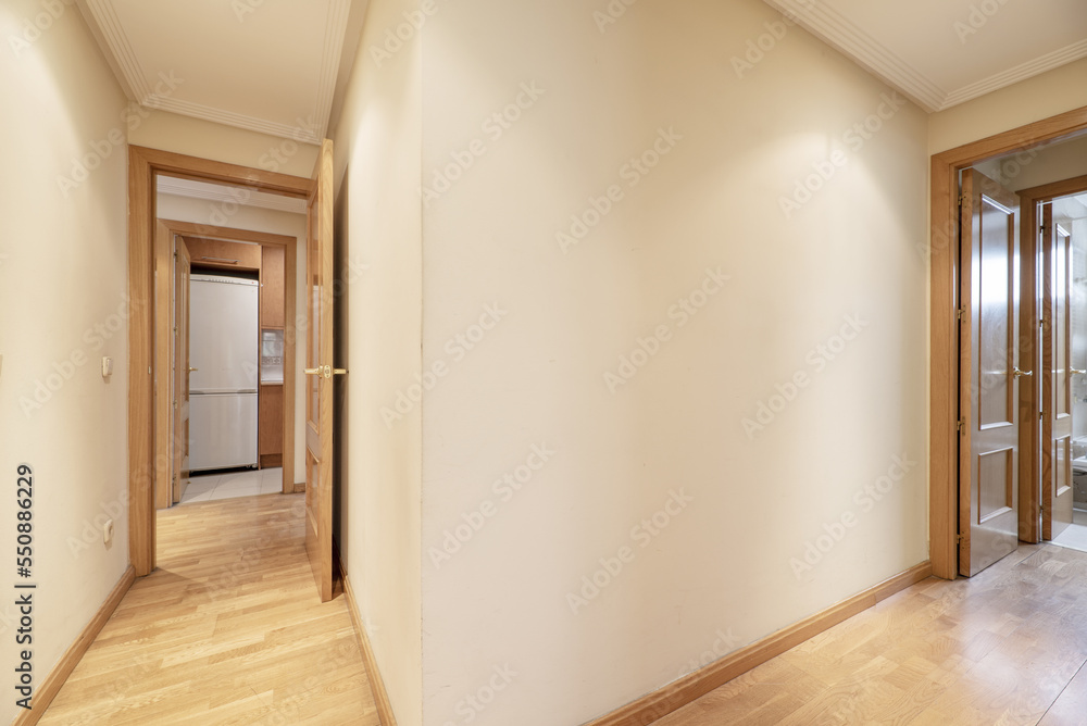 Long corridor of a house with French oak parquet flooring and door carpentry of the same material Long corridor of a house with French oak parquet flooring and door carpentry of the same material