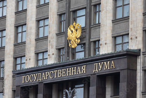 Building of Council of Labor and Defense. State Duma or Gosduma building with the golden coat of arms of Russia on the facade. Translation: State Duma. photo