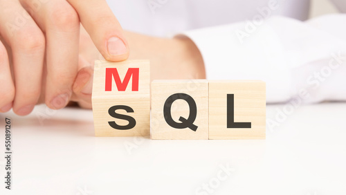 MQL or SQL symbol. Businessman turns cubes and changes words 'MQL marketing qualified lead' to 'SQL sales qualified lead'. Beautiful white background.