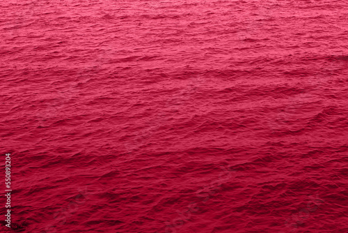 Viva Magenta toned sea water texture. Pool water with sun reflections. Trendy colour 2023 year.