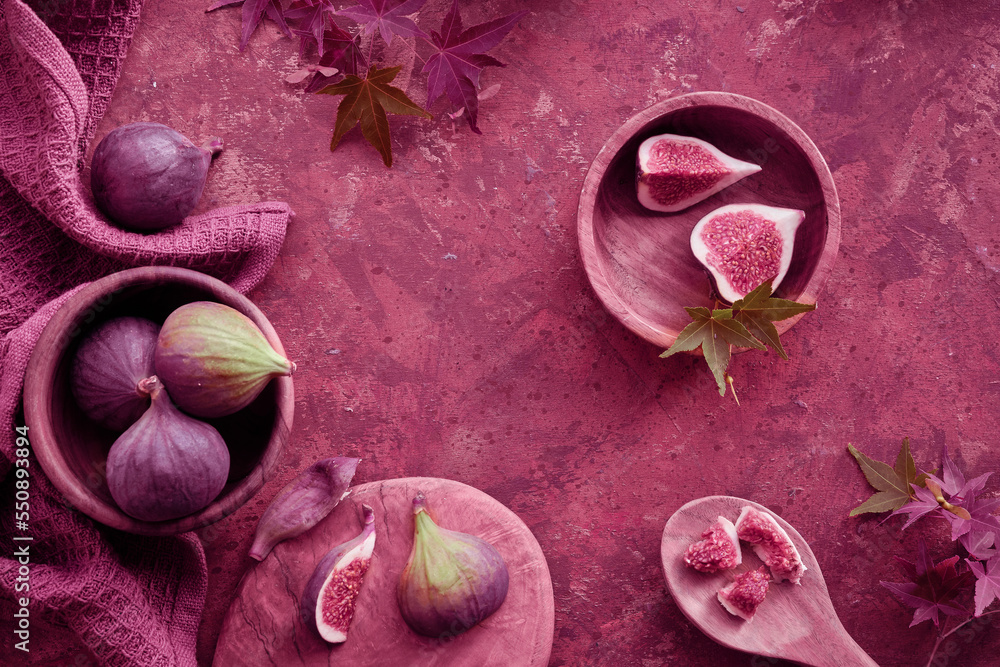 Fototapeta premium Viva Magenta color of the year 2023. Fresh halved fig fruits and dry eucalyptus and cala lily flowers painted metallic pink on bstract textured background.