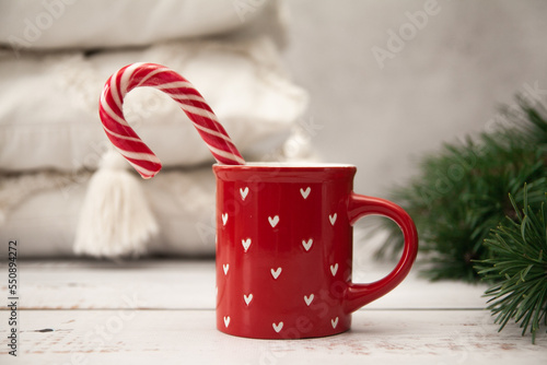 A cup with New Year's red and white candy, New Year's mood and Christmas tree branches