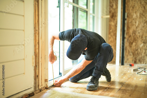 A handsome man installing Double Sliding Patio Door in a new house construction site