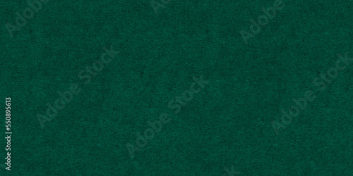 Seamless dark emerald green craft paper Christmas background texture. Rough textured thick cold pressed fibrous recycled cardboard or winter xmas holiday arts and craft card stock backdrop pattern..