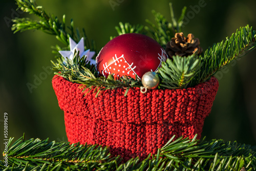 Close-up of a Christmas decoration with a red bauble in front of a natural background