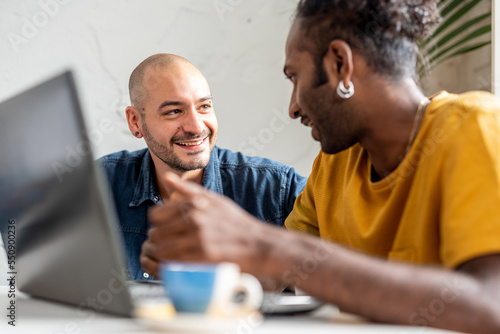 Young students using free wifi connection of university. .Happy friends spending time together working with laptop.